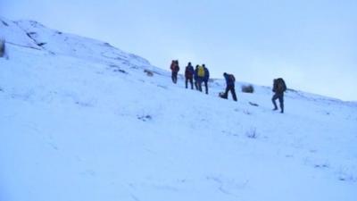 Walkers in snow covered Brecon Beacons