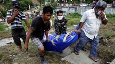 People carry body of flood victim