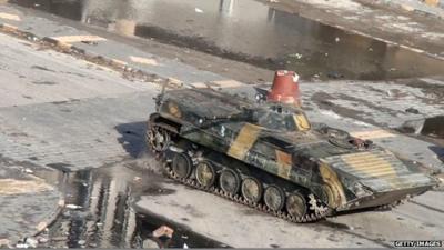 Syrian tank driving through the city of Homs