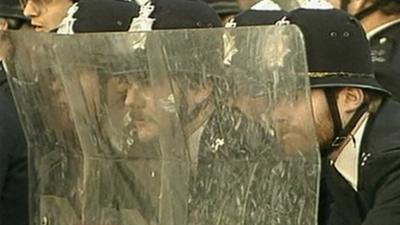 Police behind riot shields