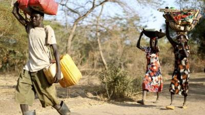 South Sudanese family carrying their belongings