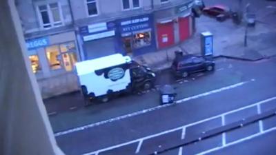 An overturned wheelie bin in the street