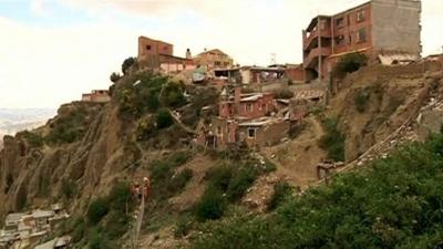 Abandoned residential buildings on a partially destroyed hillside