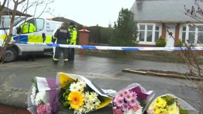 Police cordon and flowers at the scene of the fire