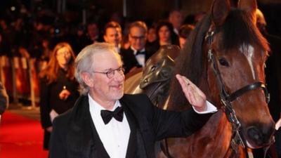 Steven Spielberg pats the horse that plays Joey