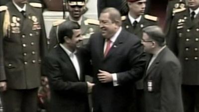 Mahmoud Ahmadinejad and Hugo Chavez laugh together.