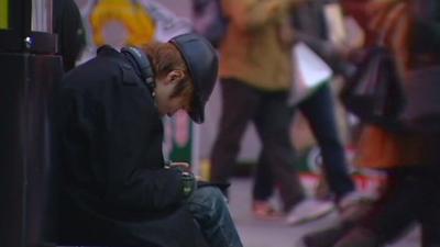 Japanese youth sits alone in a public place.