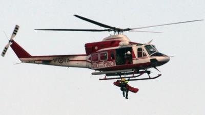 Crew member is winched into helicopter