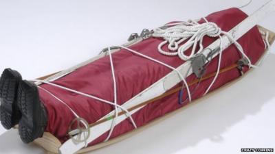 A sledge-shaped coffin complete with skis