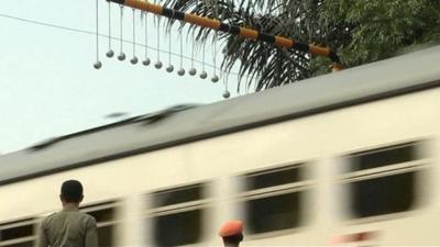 Concrete balls hanging above a train