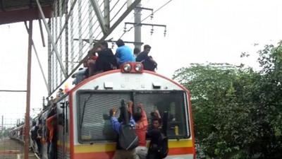 Commuters in Indonesia sitting on the roof of a train