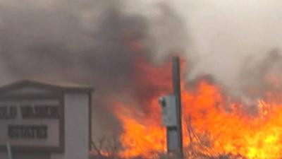 Flames surrounding utilities post and road sign