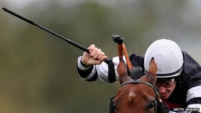 Jockey with whip in the air