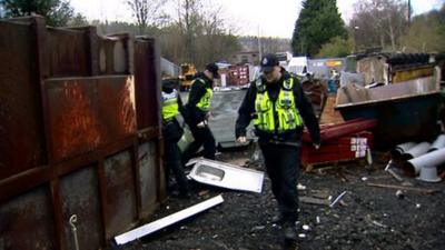 Police inspect a scrap metal dealer's yard