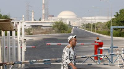 An Iranian security guard walks past Iran's Bushehr nuclear power plant