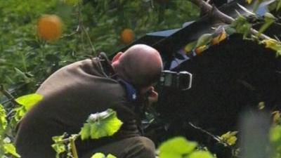 A man takes a picture of the Israeli drone's wreckage.