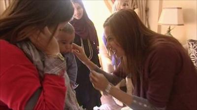 An Egyptian woman greets a mother and child