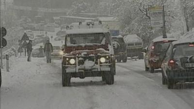 Cars trying to get through snow