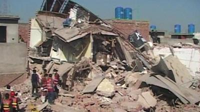 Rescuers search through the collapsed factory in Lahore