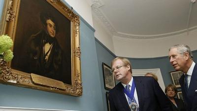 Prince Charles looks at portrait of Charles Dickens