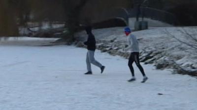 People walking across a frozen lake