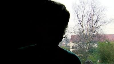 Silhouette of a woman sitting by a window