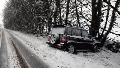 Car that has collided with a tree in snowy weather