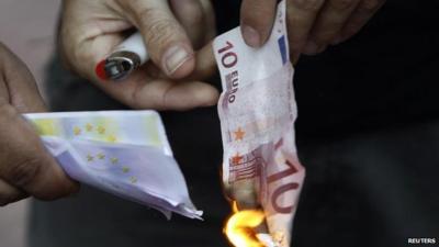 Protester sets fire to euro note