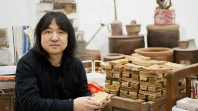 Song Dong holds a bar of soap, part of his Waste Not exhibition at The Curve (15 Feb- 12 June 2012). Photo by Jane Hobson, courtesy of Barbican Art Gallery