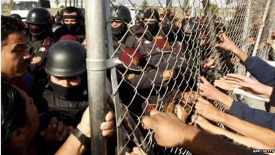 Relatives of inmates tug at the fence at Apodaca prison