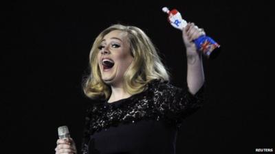 Adele holding a Brit Award