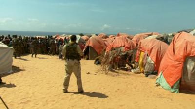 An armed soldier guards a Somali refugee camp