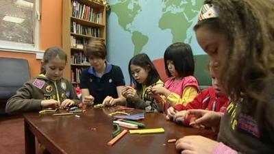 Girl guides making things with their leader