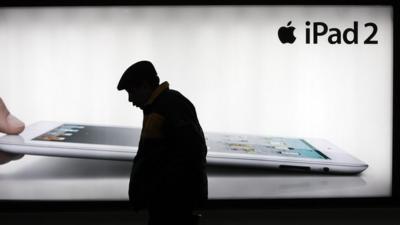 A man walks past an iPad advertisement in Shanghai, China