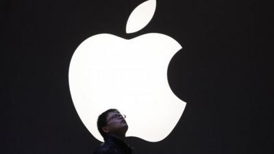 Man standing underneath Apple logo