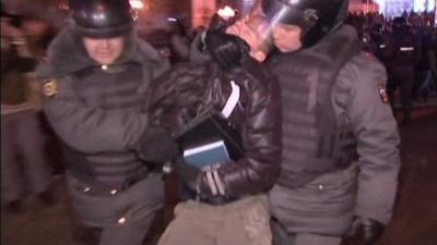 A demonstrator is arrested by two police in Moscow