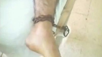 Picture from activist video purporting to show a wounded man chained to a hospital bed