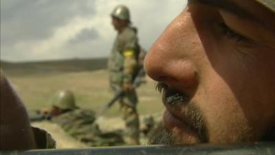 Soldier in Afghanistan looks down the barrel of a gun.