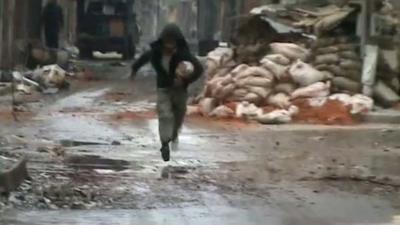 An image grab from a video uploaded on YouTube on March 7, 2012, shows a man running in the Homs neighbourhood of Bab Tadmur