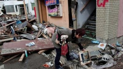 Woman sifting through rubble a few days after the earthquake hit