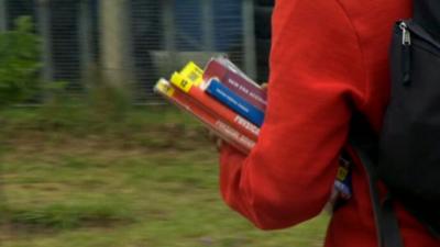 Girl in school uniform carrying books