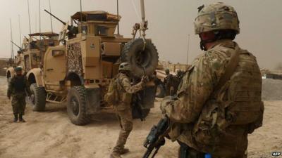 US soldiers keep watch at the entrance of a military base near Alkozai village following the shooting of Afghan civilians in Kandahar Province.