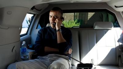 President Barack Obama talks on the telephone with Afghanistan President Hamid Karzai from inside his limousine.