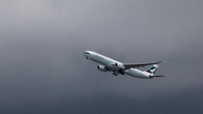 A Cathay Pacific aircraft takes off in grey skies from Hong Kong's international airport