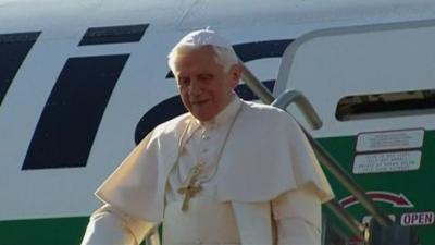 The Pope exits his plane on the runway after landing in Mexico.