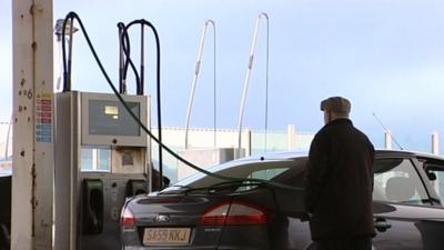 Man refuels at the pump.