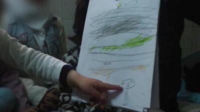 A child in Syria draws as part of art therapy