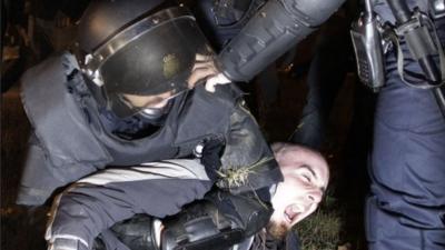 Police officer holds down striker in Spain