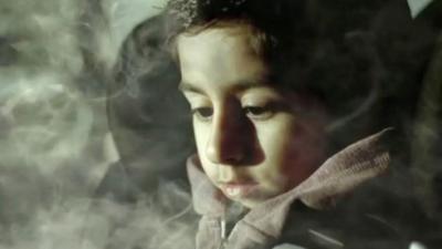 Child surrounded by cigarette smoke in car