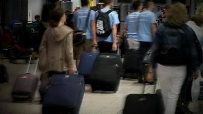 Air passengers carrying luggage in an airport